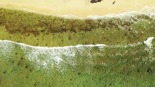 Aerial flying over landscape of idyllic island beach trip by shallow ocean with white sandy backgrou