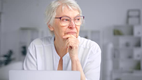 Thoughtful old businesswoman with short grey hair