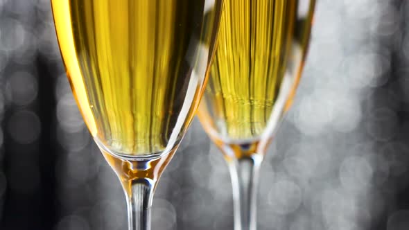 Close up of two champagne glasses with silver glitter tinsel christmas decoratio