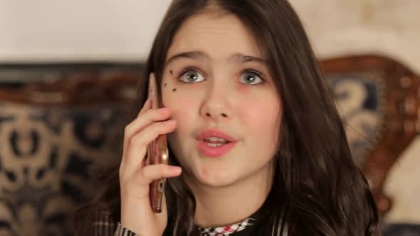 Teen Girl is Worried Talking on a Smartphone