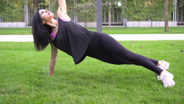 An Athletic Slender Woman Trains Does Fitness and Does Plank Exercise