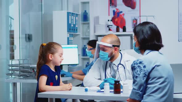 Little Girl Speaking with Doctor During Consultation