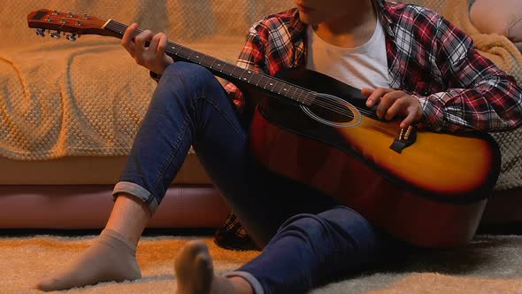 Teenager Practicing Playing Guitar at Home, Writing Song for School Performance