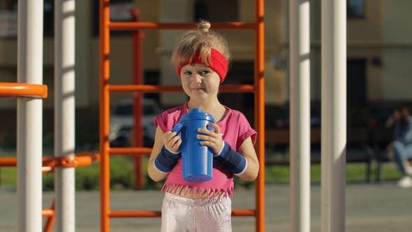 Girl in Sportswear Drinking Water for Refreshment After Fitness Exercises. Little Athletic Child