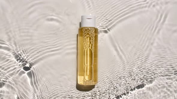 Cosmetic Bottle Vial on Water Surface with Drops