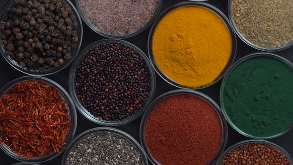 Assortment colorful spices, seeds and herbs for cooking food rotate, top view