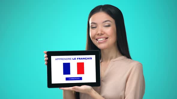 Female Holding Tablet With Learn French Application, Ready to Start Course