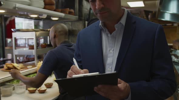 Caucasian man writing in the kitchen