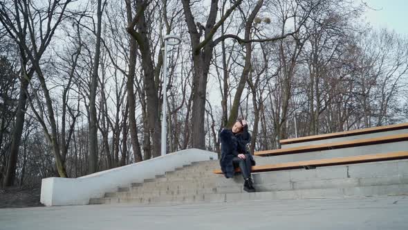 Girl sits on bench in the park. 