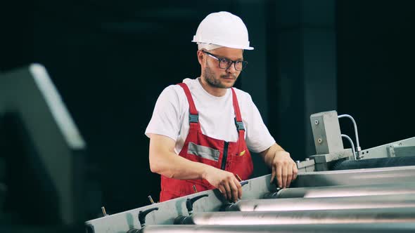 Male Worker Is Adjusting a Rolling Transporter