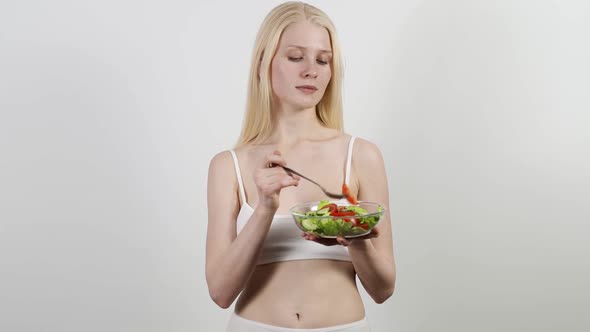 Beautiful Young Female Enjoying Healthy Vegetable Salad and Looking at Camera