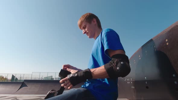 Man In Skate Park Puts On Wrist Protection