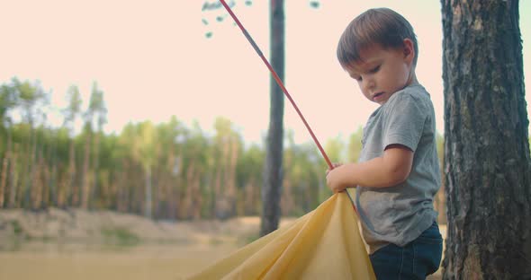 The Boy Helps His Father To Set Up and Assemble a Tent in the Forest. Teaching Children and