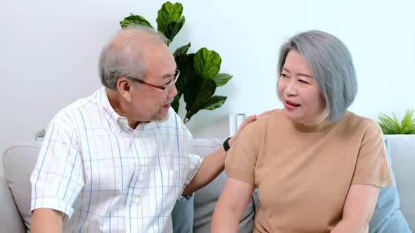 Portrait of Asian senior family and a young caregiver sitting on a chair in a living room