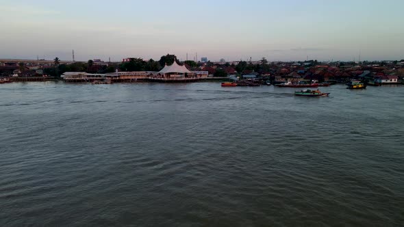 Township of Palembang while flying over Musi river with sailing boat