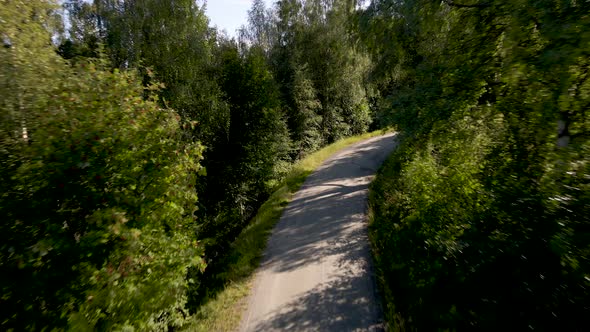 Old road snaking up forested mountainside; first person view