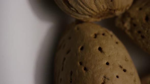 Cinematic, rotating shot of almonds on a white surface