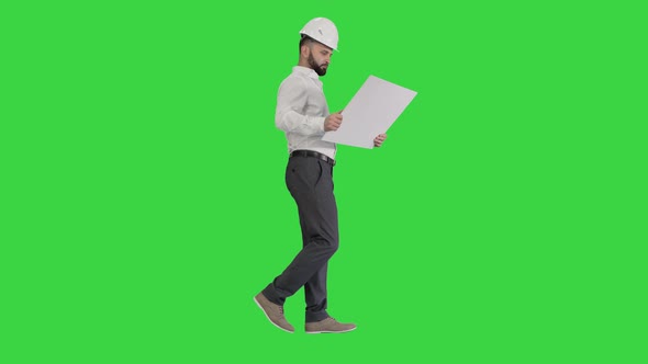 Young Construction Architect Walking Looking at Blueprint on a Green Screen, Chroma Key