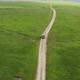 Top view on the driving car of the mountain road through the green field - VideoHive Item for Sale