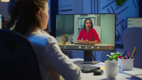 Manager Talking with Coworker During Video Conference at Midnight