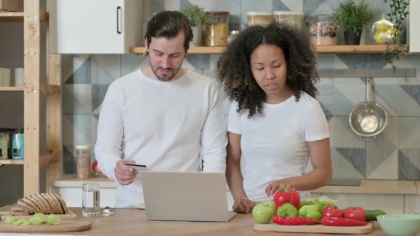 Mixed Race Couple Making Online Payment on Laptop