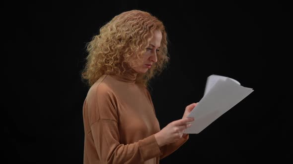 Nervous Caucasian Woman Throwing Away Paperwork Rehearsing Speech at Black Background
