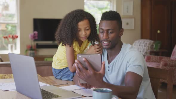 African american father and daughter looking a digital tablet