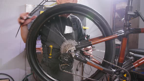 Bicycle Service Concept. A Young Man Repairs and Maintains a Bicycle