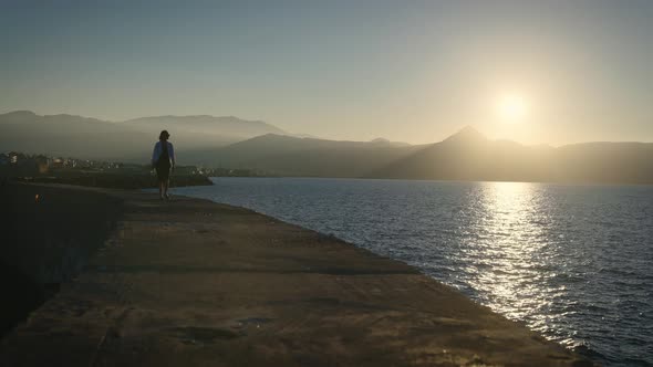 Silhouette of a Slender Young Woman Against the Setting Sun