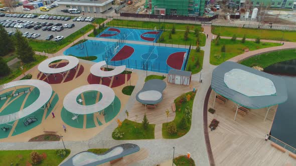 Children Playground with Roofs and Sports Fields Near Pond