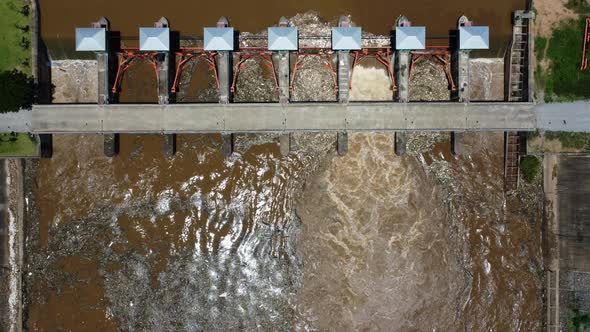 Aerial view of the water released from the concrete dam's drainage channel as the overflow