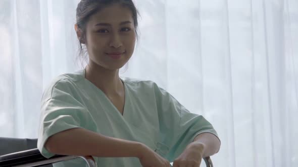 Happy Patient Sitting on Wheelchair in Hospital