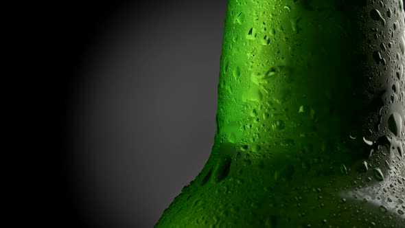 Wet Green Beer Bottle Close-up. High Quality Advertizing Shot of a Rotating Bottle of Beer