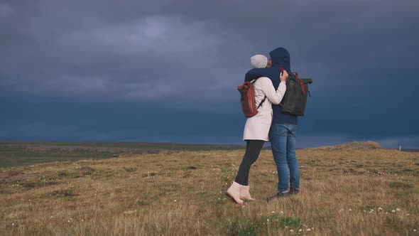 Young Loving Couple Hugging in Field on Background of Epic Dramatic Clouds Slow Motion