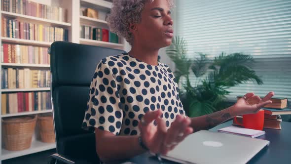 Calm African American Woman with Closed Eyes Meditating at Workplace