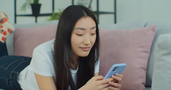 Beautiful and Happy Young Woman Lying on the Sofa