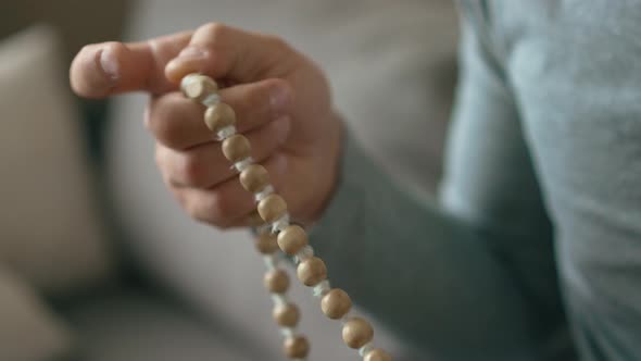 Beads in a Hand of a Man