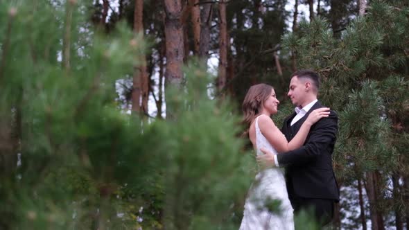 Happy Smiling Newlyweds Couple Holding Each Other on Their Wedding Day in Nature