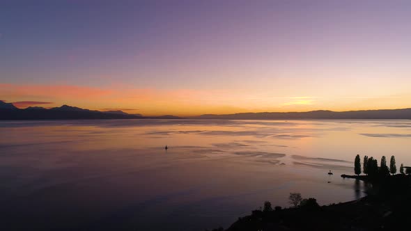 Flying high towards sailboat on Lake Léman with beautiful sunset colorsLutry, Lavaux - Switzerland