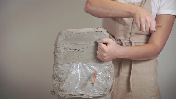 Woman Cutting Clay in Pieces.