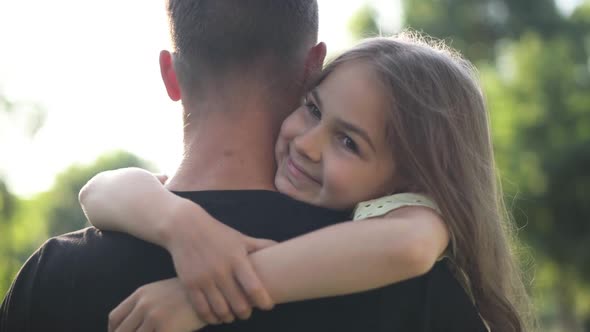 Portrait of Happy Girl Hugging Man Outdoors in Summer Spring Park Looking Away