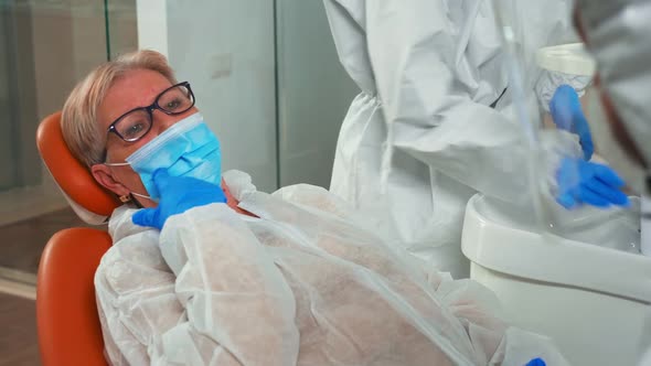 Dentist and Woman with Mask Talking About Dental Problem