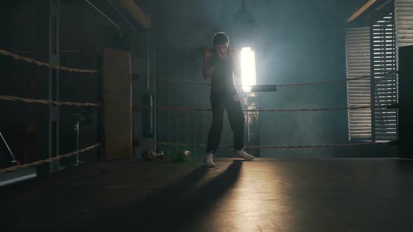 Adult Man Crouch And Boxing On The Ring With Yellow Ropes In Industrial Interior