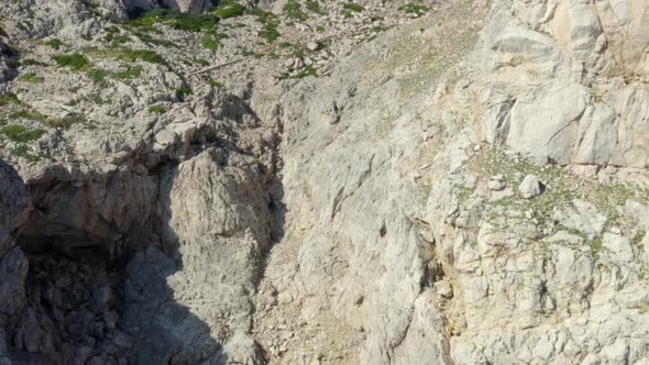 Guy Standing on Edge of Cliff with Blue Water Waves Crushing on Tropical Island Mallorca