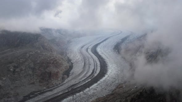 Beautiful view of Aletsch glacier covered around with fog, Switzerland