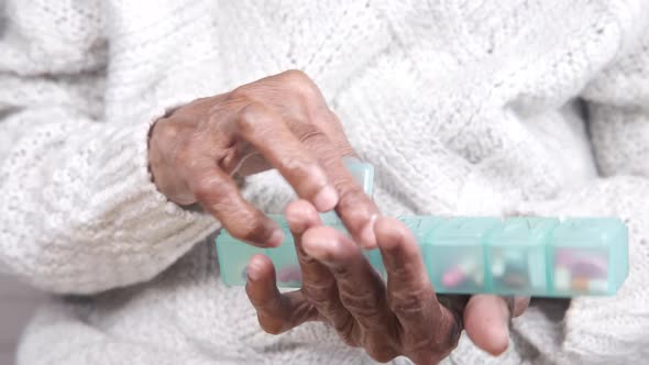 Senior Women Hand Taking Pill From a Pill Box