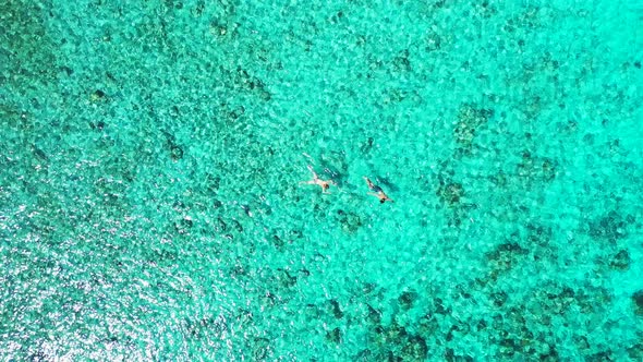 Beautiful aerial island view of a sandy white paradise beach and aqua blue ocean background in color