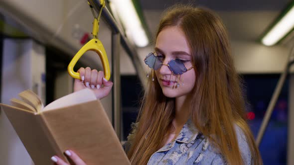 Portrait of Attractive Young Adult Woman Stay at Empty Subway Train and Reading Interesting Book