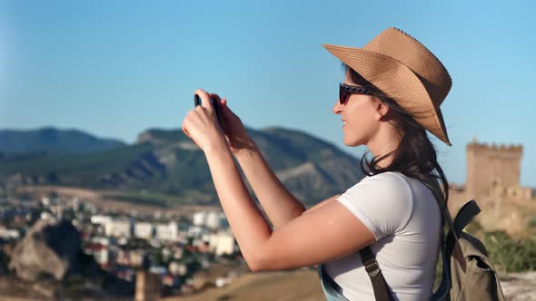 Happy Travel Female Making Picture of Landscape From Mountain at Sunset Using Smartphone