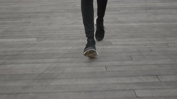 Female Runner in Leggings and Sneakers Jogging Outdoors